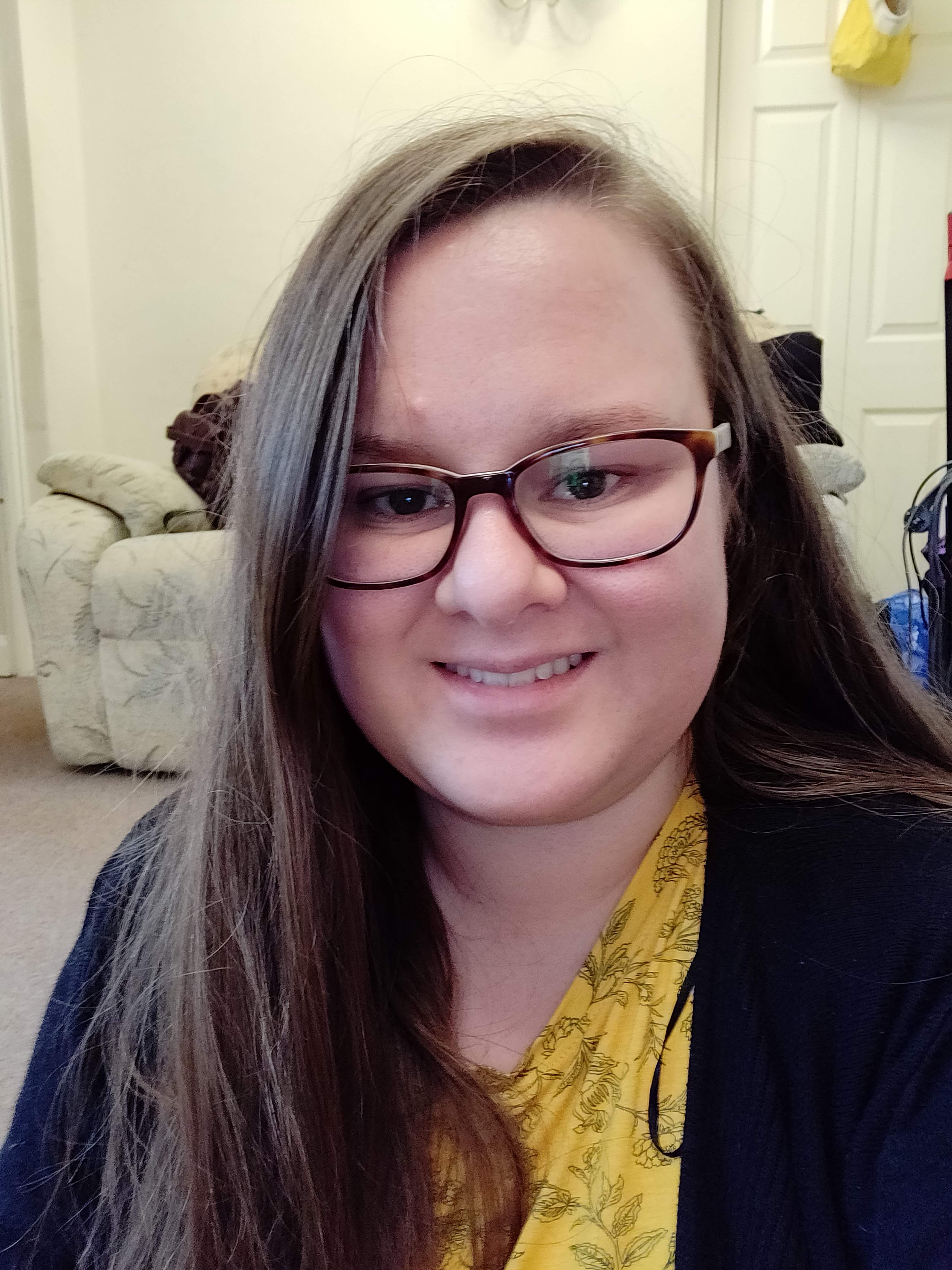 A 20-something year old woman with long hair and glasses.